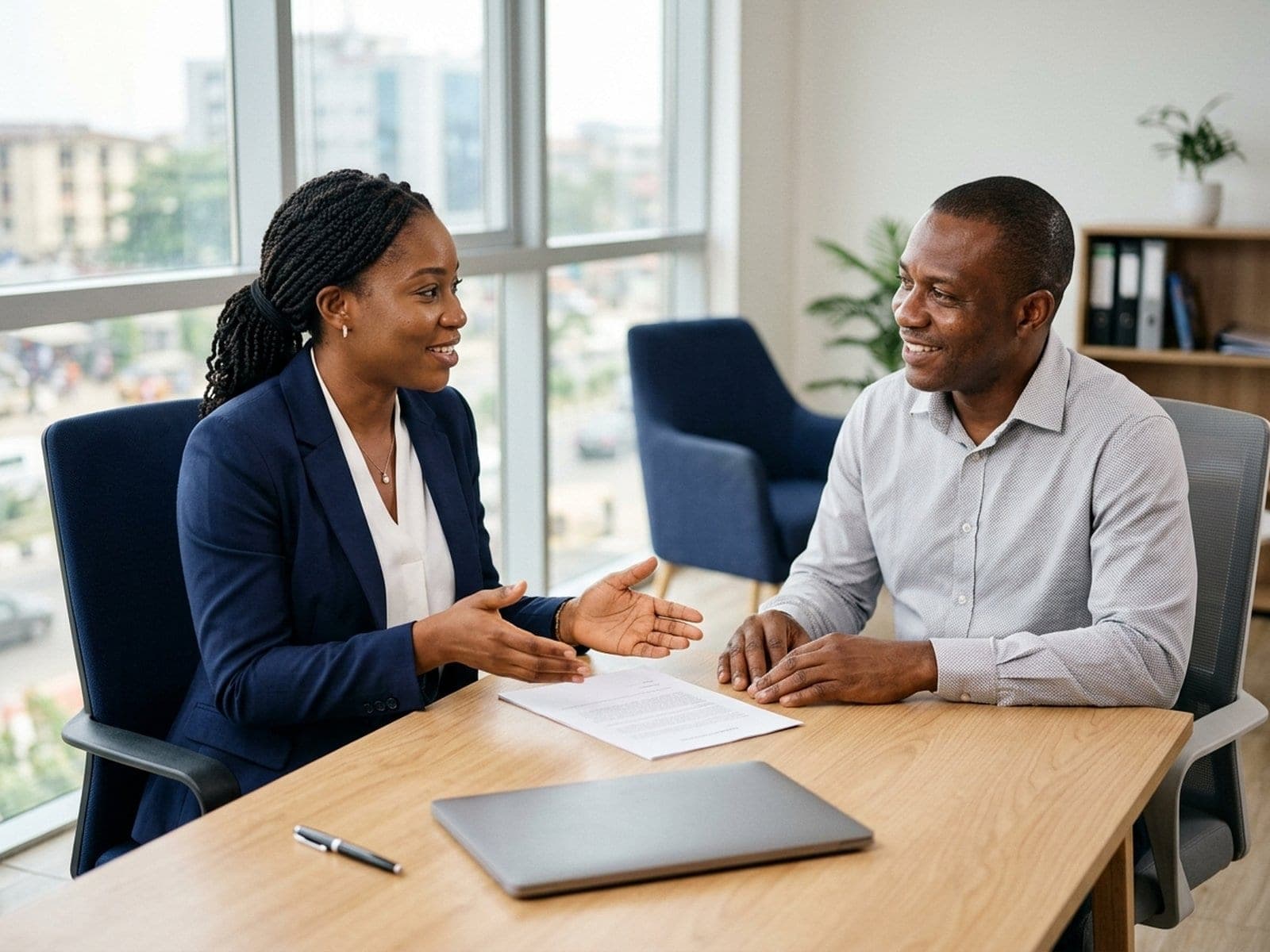 A foreign exchange adviser talking a customer through the details of a request at a desk.